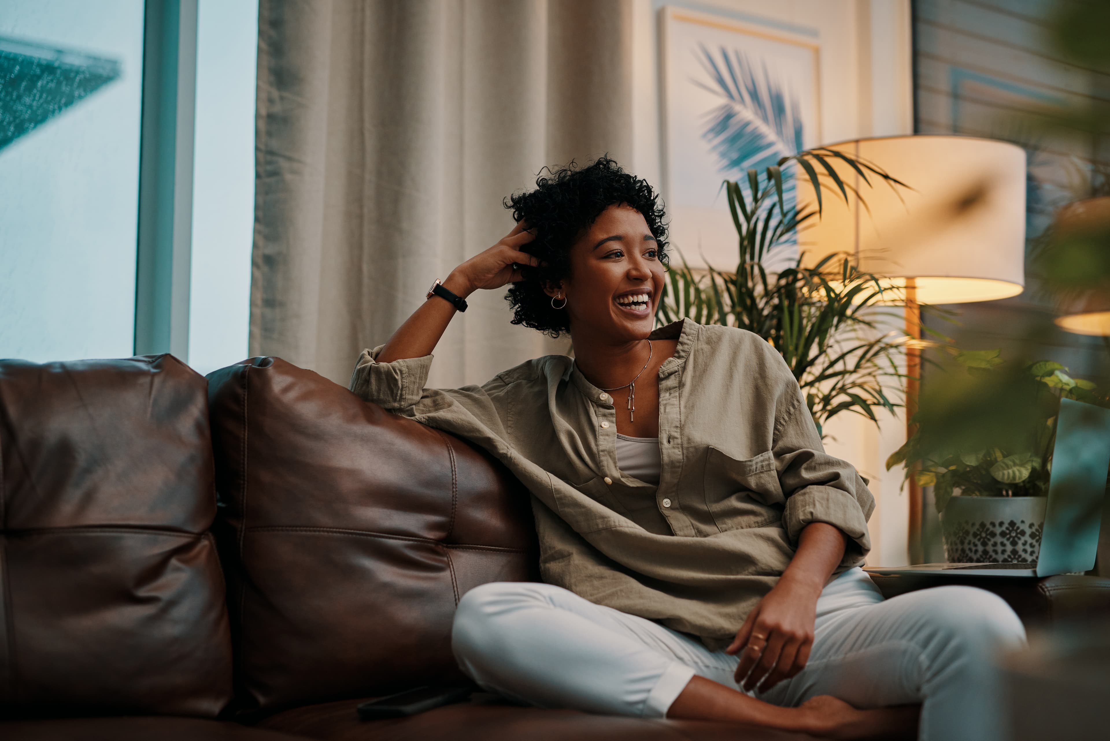 Woman sitting on couch using laptop